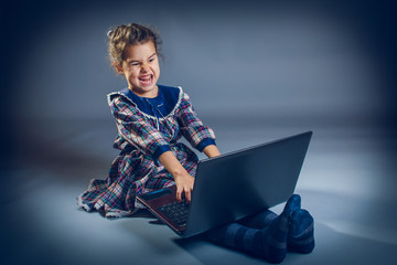 teen girl the floor playing laptop surprised on