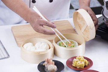 Chef using chopsticks hold Chinese dumpling