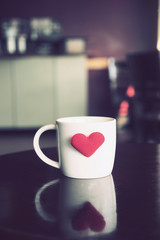 vintage color tone of  cup of coffee with red heart on the table