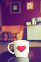 vintage color tone of  cup of coffee with red heart on the table