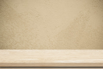 Empty wooden table over grunge cement wall.