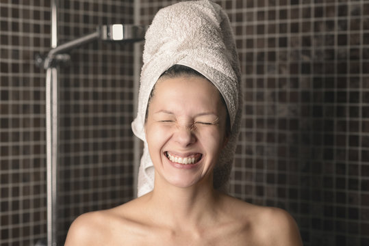 Grinsende spitzbübische Frau steht in der Dusche