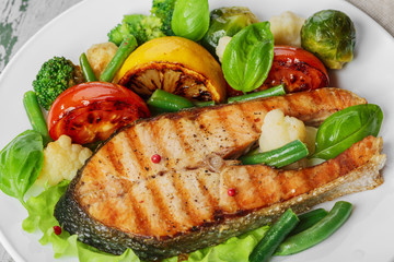 steak grilled salmon with vegetables on a plate