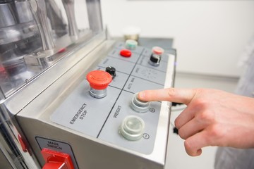 Pharmacist pressing button on machine
