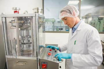 Pharmacist using machinery to make medicine