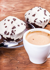 two cupcakes with a cup of coffee