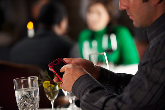 Restaurant: Man Texts On Cell Phone During Dinner