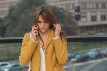 Redhead girl listening to music in the city streets