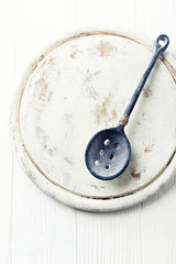 Rustic cast iron spoon on a wooden chopping board