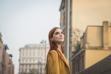 Redhead girl posing in the city streets