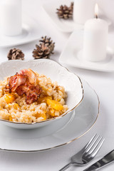 risotto with pumpkin and bacon in white bowl
