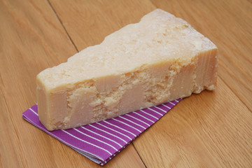 pezzo di formaggio grana su tavolo di legno