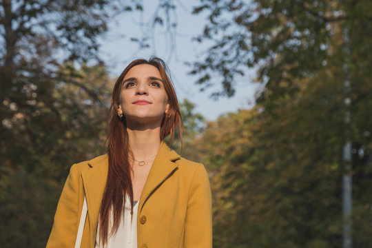 Redhead girl posing in a city park