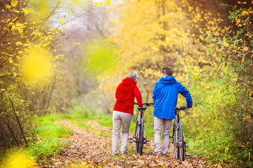 Fototapeta premium Active seniors walking with bike