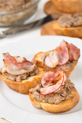 small bread pieces with homemade pate on white plate