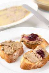 small bread pieces with homemade pate on white plate