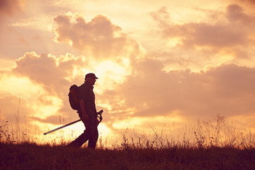 Mann mit Cap und St&ouml;cken bergab