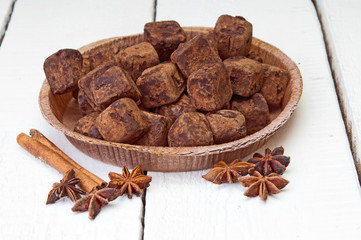 Chocolate truffles and cinnamon on wooden background