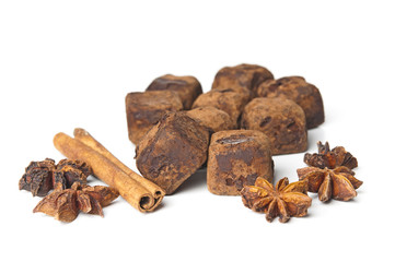 Chocolate truffles and cinnamon on white background