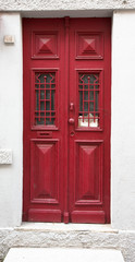Obraz premium Old red wooden door with window and grid