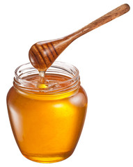 Honey flowing into glass jar. File contains clipping paths.