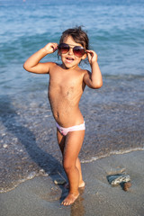 Funny baby girl with large sunglasses.