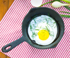 Scrambled eggs with dill on cast iron skillet