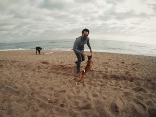 Man plays with his dog on the beach