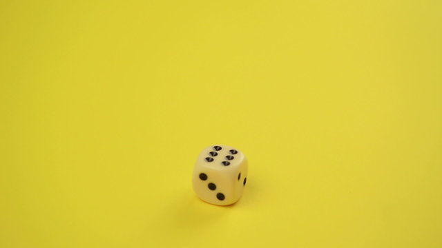 Rolling Dice on Yellow Background as Gambling Concept