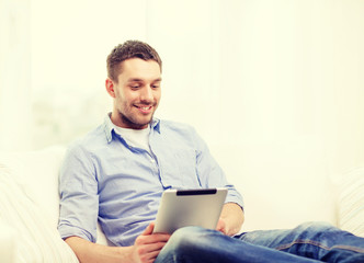 smiling man working with tablet pc at home