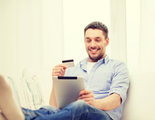 smiling man working with tablet pc at home