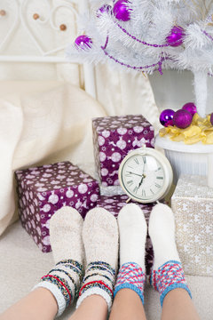 two feet in warm knit socks near the gifts and watches