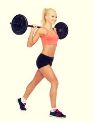 Obraz premium smiling sporty woman exercising with barbell