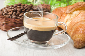 coffee in glass cup with croissants and coffee beans