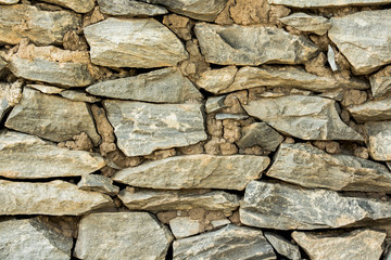 Cracked real stone wall surface with cement.