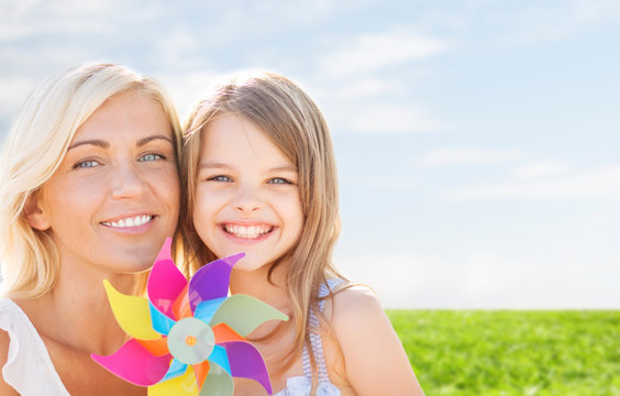happy mother and little girl with pinwheel toy