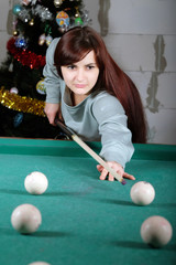 Beautiful woman playing billiard