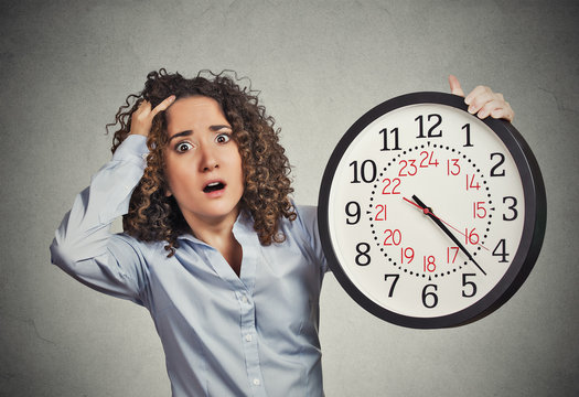 stressed corporate employee holding clock looking anxiously runn