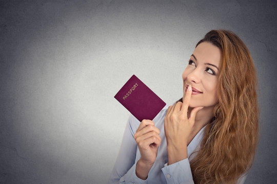 smiling woman holding passport looking up imagining new life