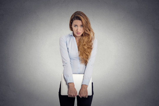  Insecure worried young woman holding laptop feels awkward