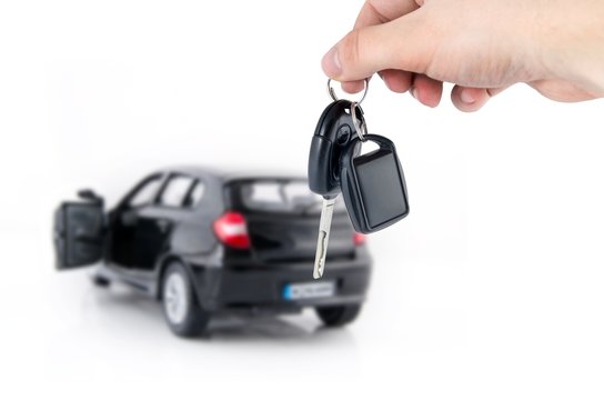 Hand holding keys to new car. Buy or selling business compositio