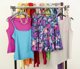 Wardrobe with colorful cute summer clothes displayed on a rack.