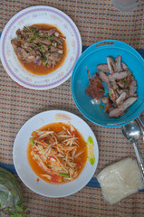 Papaya salad (som tum Thai) with sticky rice , grilled beef and