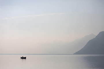 Fototapeta na wymiar Lone Boat in the Lake Garda