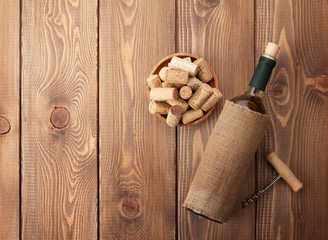 White wine bottle, bowl with corks and corkscrew. View from abov