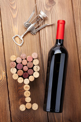 Red wine bottle, glass shaped corks and corkscrew. View from abo