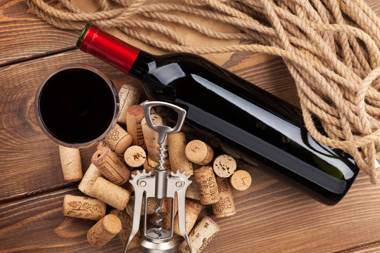 Red wine bottle, glass, corks and corkscrew. View from above