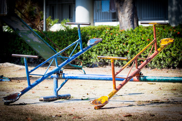 Colorful old and rusty iron seesaw on playground