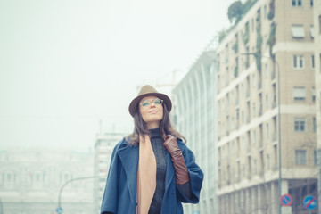 Fototapeta premium Beautiful young brunette posing in the city streets