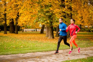 Foto op Plexiglas Couple jogging in autumn nature © Martinan